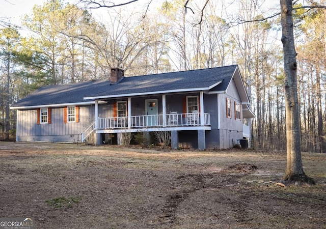 ranch-style house with a chimney, central air condition unit, a shingled roof, covered porch, and crawl space