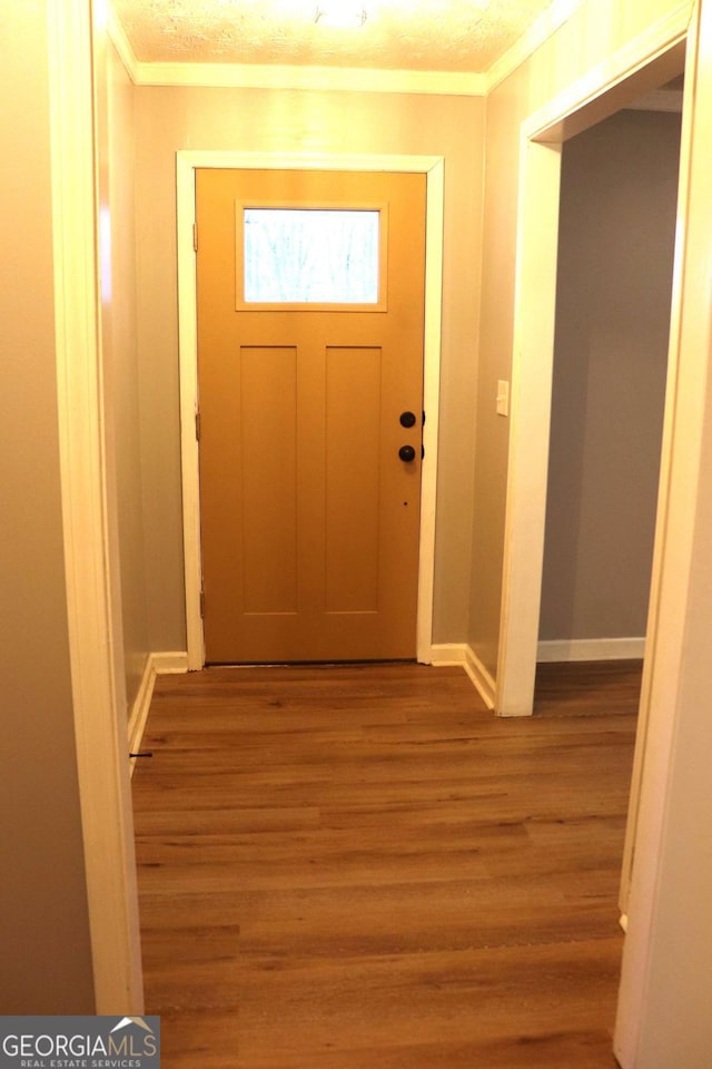 entryway with baseboards, ornamental molding, and light wood-style floors