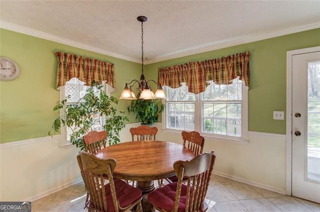 tiled dining area with ornamental molding, a healthy amount of sunlight, and an inviting chandelier