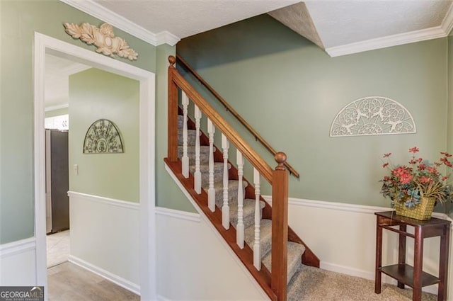 stairs with carpet floors, ornamental molding, and baseboards