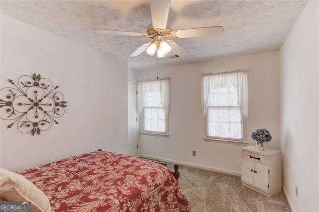 bedroom featuring light carpet, ceiling fan, a textured ceiling, and baseboards