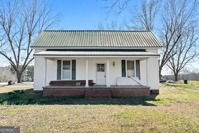 view of front of home with metal roof, a front lawn, and a porch