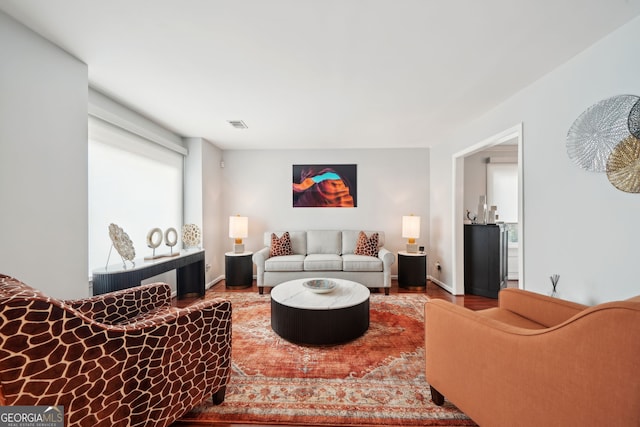 living area featuring wood finished floors, visible vents, and baseboards