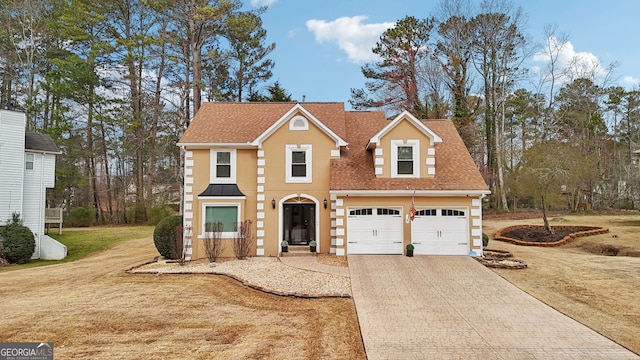 view of front of house with a front lawn, decorative driveway, and roof with shingles