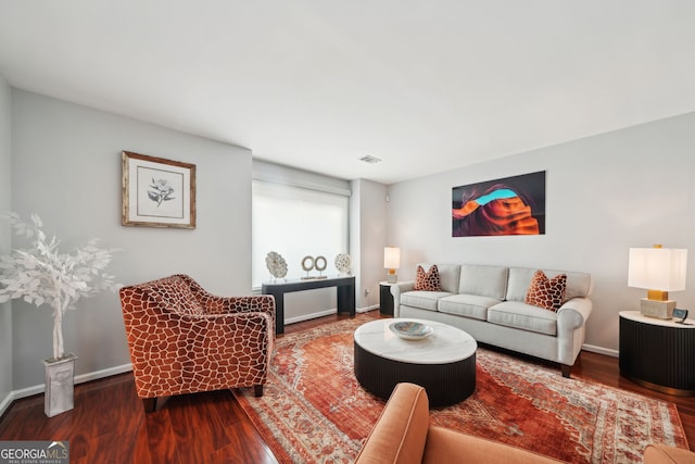 living area featuring visible vents, baseboards, and wood finished floors