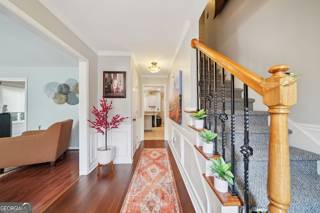 foyer featuring a wainscoted wall, a decorative wall, stairway, ornamental molding, and wood finished floors