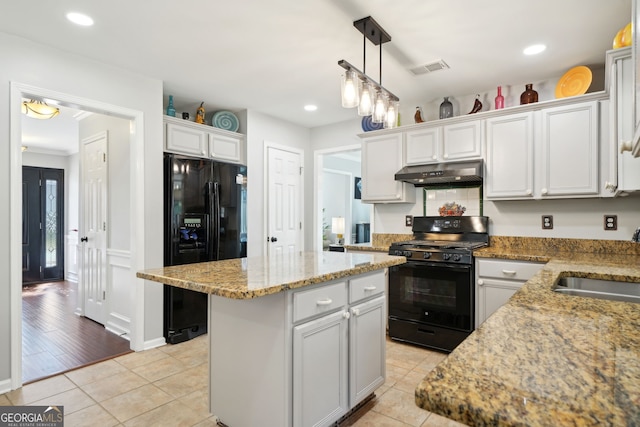 kitchen featuring light tile patterned floors, under cabinet range hood, a kitchen island, a sink, and black appliances