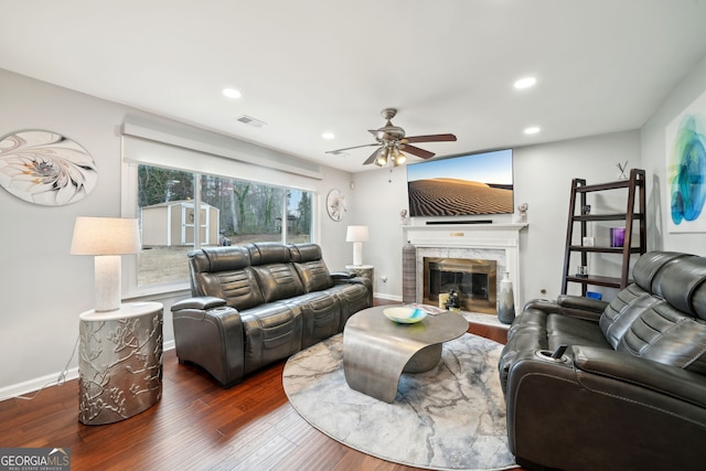 living area featuring recessed lighting, visible vents, wood finished floors, and a high end fireplace