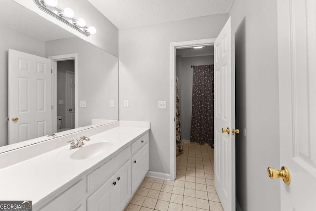 bathroom featuring baseboards, toilet, tile patterned floors, a textured ceiling, and vanity