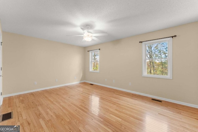 unfurnished room featuring light wood-type flooring and visible vents