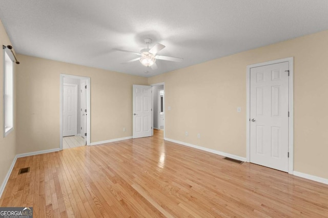 unfurnished bedroom featuring light wood-type flooring, baseboards, and visible vents