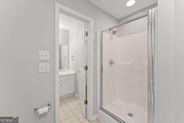 full bathroom with a shower stall, vanity, and tile patterned floors