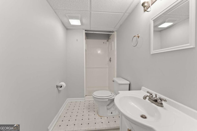 full bath featuring a paneled ceiling, toilet, a shower stall, baseboards, and tile patterned floors