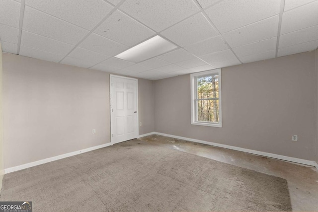 empty room with a drop ceiling and baseboards