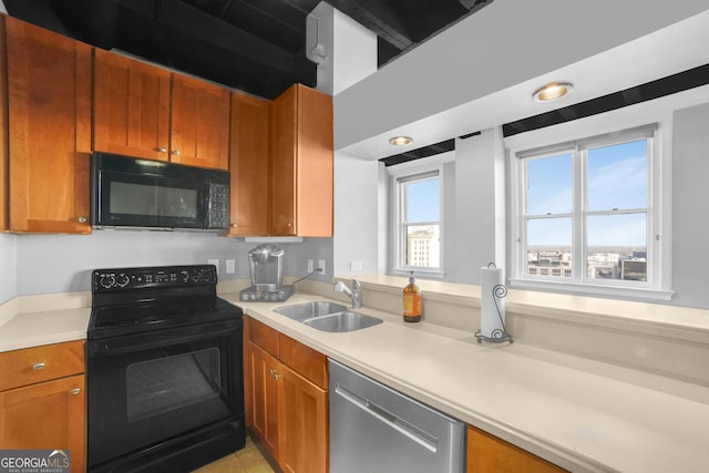 kitchen with black appliances, a sink, light countertops, and brown cabinets