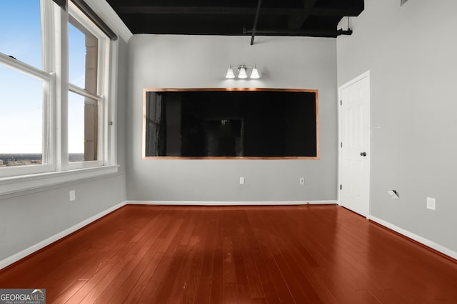 empty room featuring hardwood / wood-style flooring and baseboards