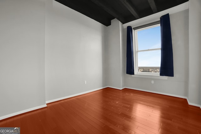 unfurnished room featuring baseboards and hardwood / wood-style flooring