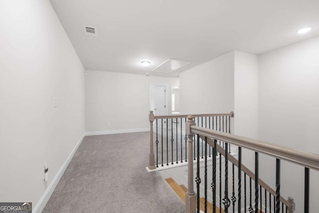 corridor with baseboards, visible vents, an upstairs landing, carpet floors, and recessed lighting