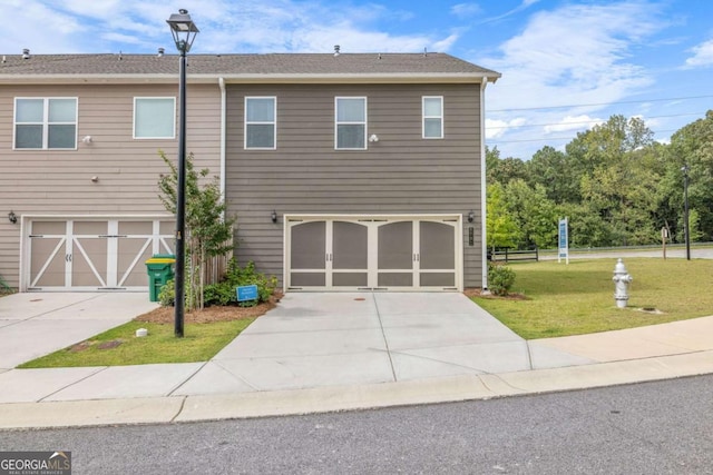 view of front facade featuring a front yard, driveway, and an attached garage