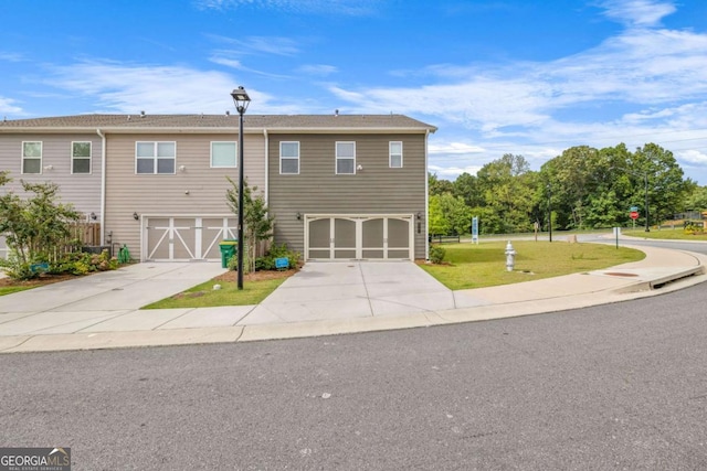 view of front facade featuring driveway, a garage, and a front yard