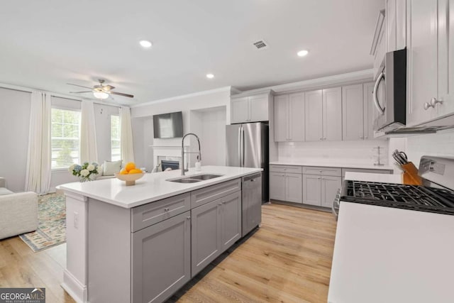 kitchen with visible vents, gray cabinetry, appliances with stainless steel finishes, open floor plan, and a sink