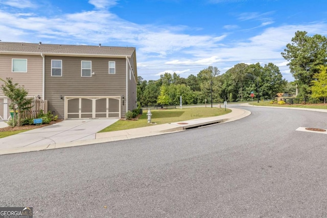 view of home's exterior featuring an attached garage, a lawn, and concrete driveway