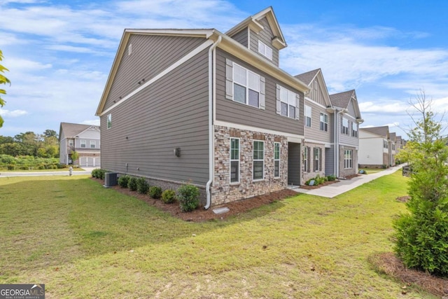 view of property exterior featuring stone siding, a lawn, and central air condition unit