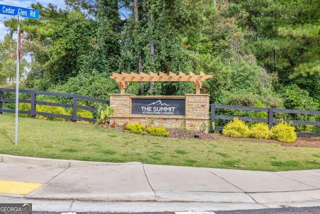 community sign with a lawn and fence