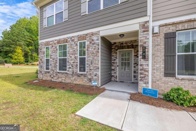 view of exterior entry featuring a yard