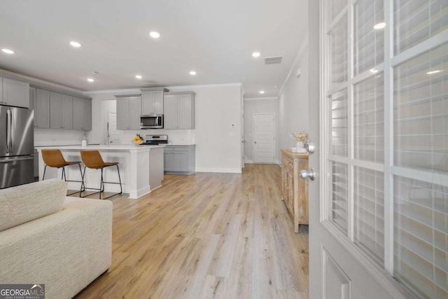 kitchen featuring gray cabinets, visible vents, stainless steel appliances, and crown molding