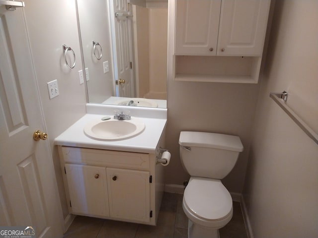 bathroom featuring baseboards, vanity, toilet, and tile patterned floors