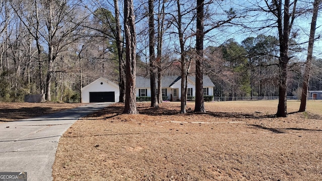 ranch-style home with a garage, an outbuilding, and fence