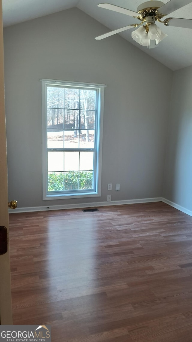 empty room featuring baseboards, visible vents, a ceiling fan, lofted ceiling, and wood finished floors