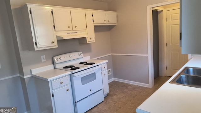 kitchen with white range with electric cooktop, light countertops, white cabinets, a sink, and under cabinet range hood