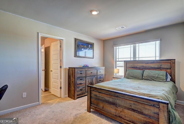 bedroom featuring baseboards, visible vents, and light colored carpet