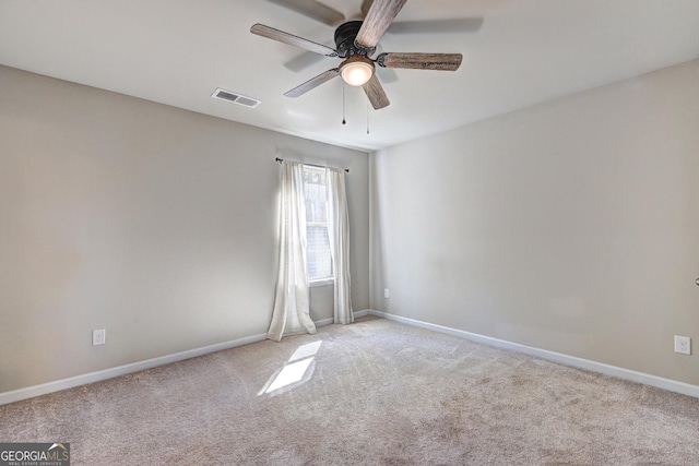 empty room featuring carpet floors, visible vents, ceiling fan, and baseboards