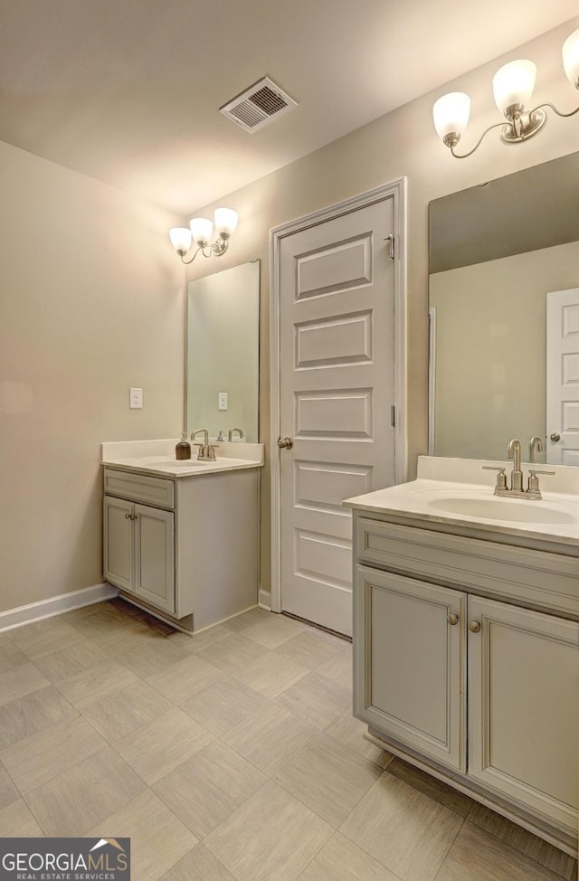 full bathroom with two vanities, visible vents, a sink, and baseboards