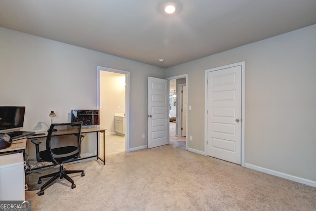 office area featuring baseboards and light colored carpet