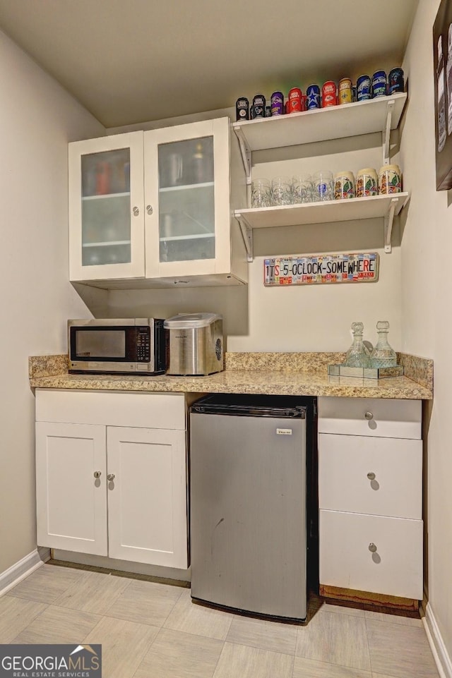 bar with stainless steel appliances and baseboards