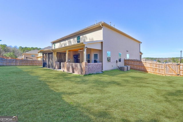 rear view of house featuring a fenced backyard and a lawn