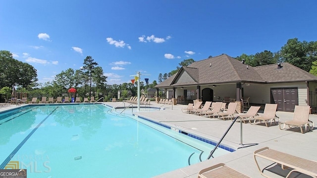 community pool with fence and a patio