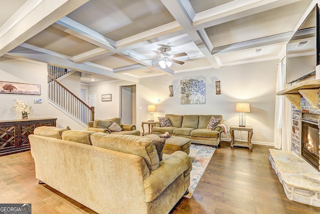 living area with hardwood / wood-style flooring, a fireplace, coffered ceiling, baseboards, and stairs