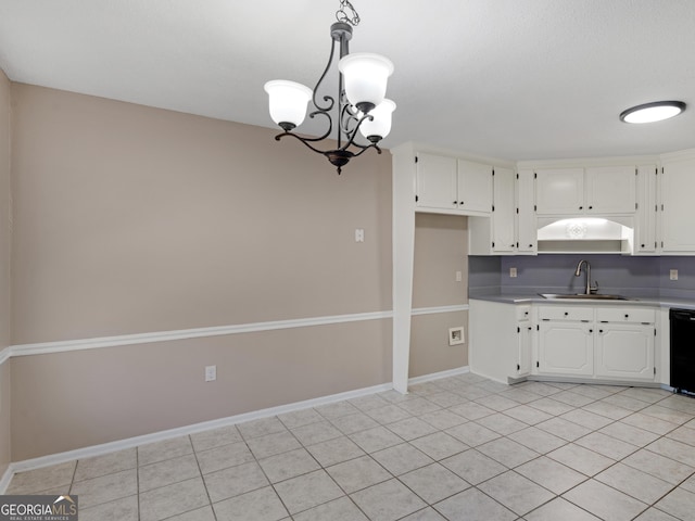 kitchen with decorative light fixtures, light tile patterned floors, white cabinetry, a sink, and baseboards