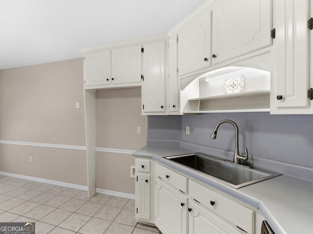 kitchen featuring light tile patterned floors, white cabinetry, light countertops, and a sink