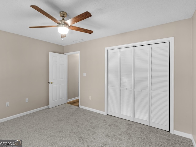 unfurnished bedroom featuring visible vents, baseboards, a ceiling fan, carpet floors, and a closet