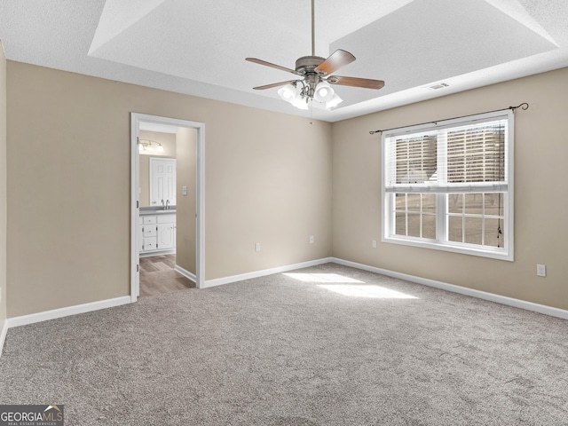 unfurnished bedroom featuring a textured ceiling, carpet, visible vents, and baseboards