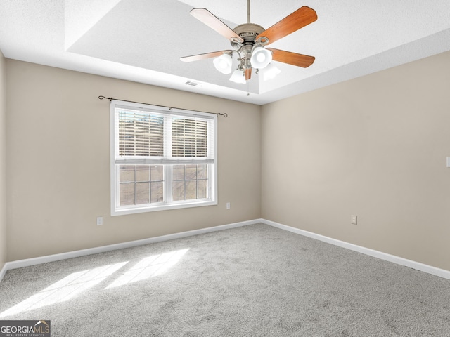 spare room featuring carpet flooring, visible vents, ceiling fan, and baseboards