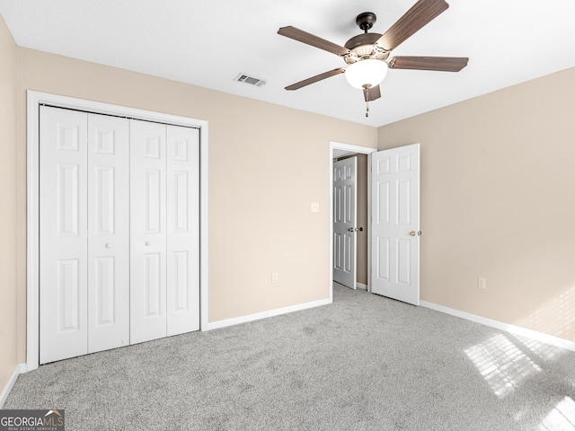 unfurnished bedroom with carpet floors, a closet, visible vents, and baseboards