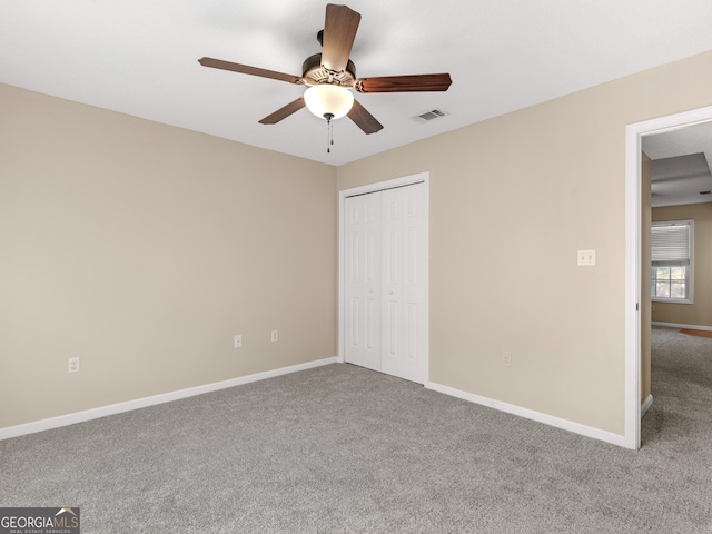 unfurnished bedroom with a ceiling fan, visible vents, baseboards, a closet, and carpet