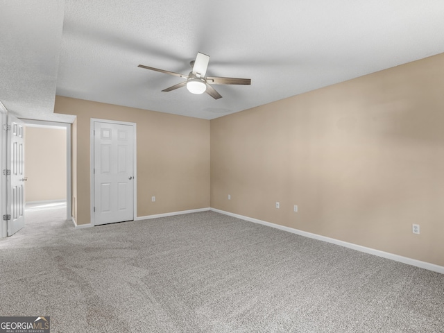 carpeted empty room featuring a textured ceiling, baseboards, and a ceiling fan